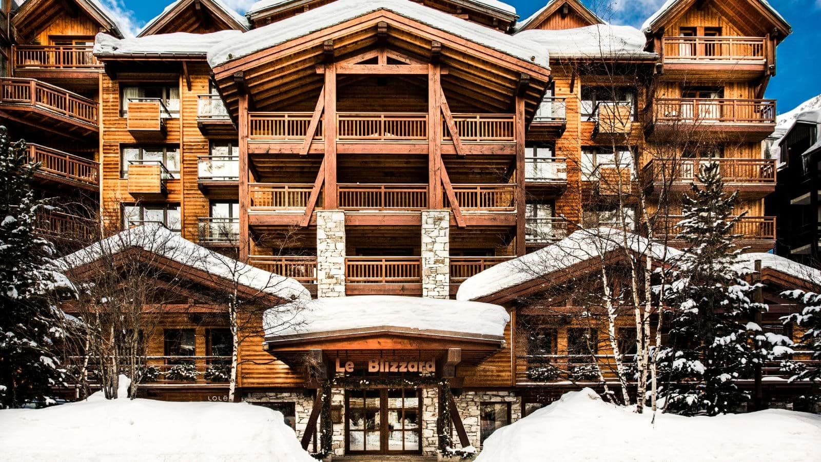 Ski-in lodge exterior with private balconies and timber architecture