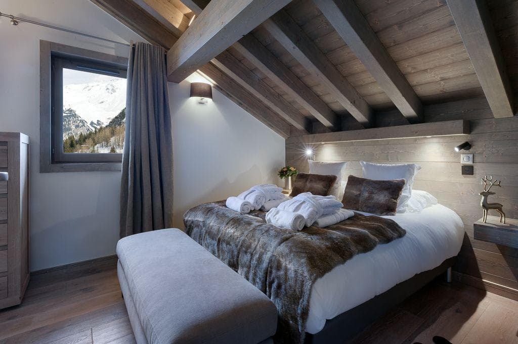 Top-floor bedroom with vaulted timber ceilings and mountain views