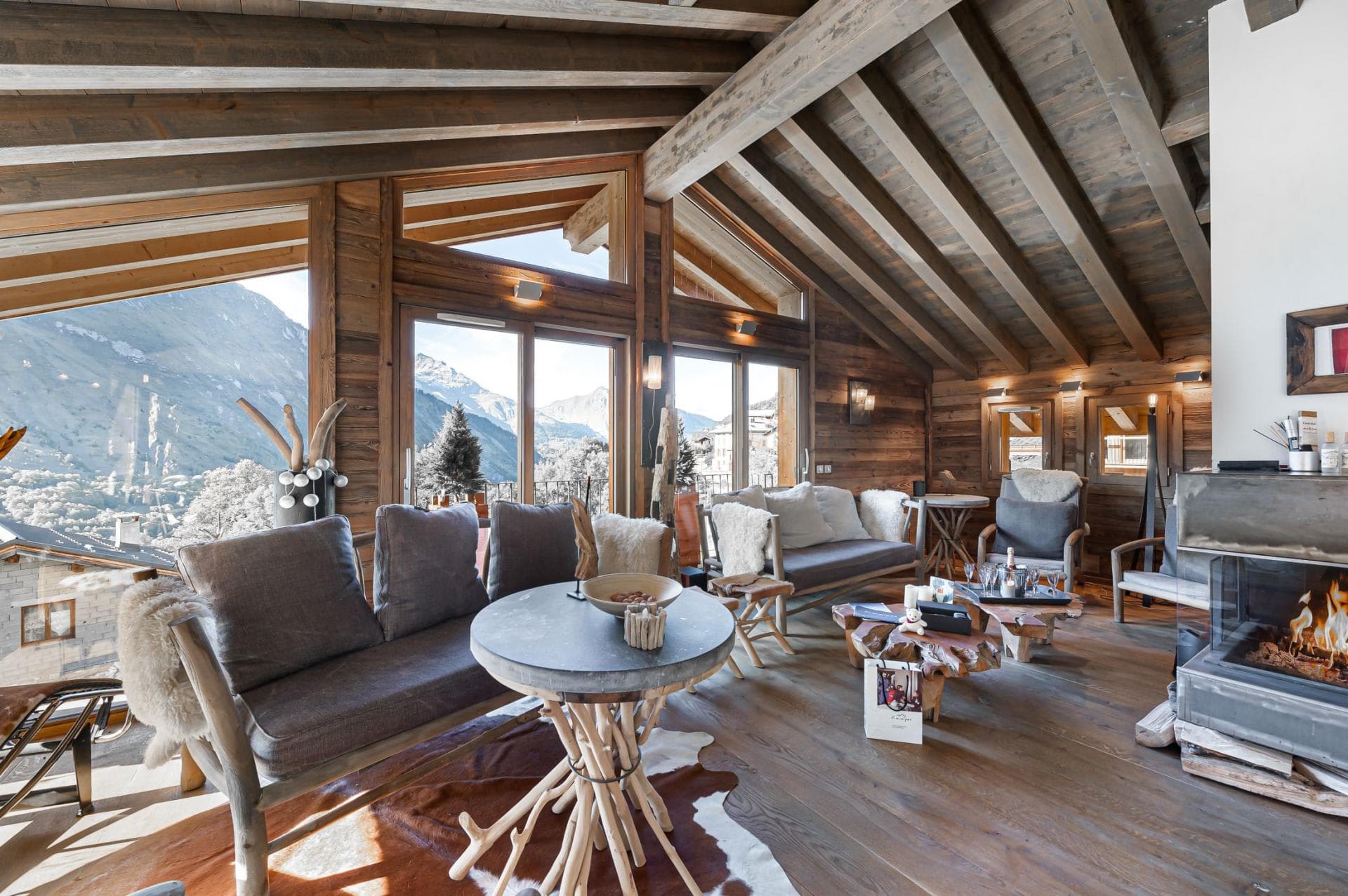 Living area with wood-burning fireplace and floor-to-ceiling mountain views
