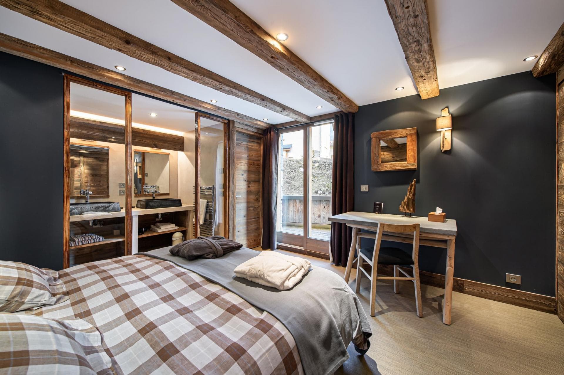 Bedroom with work desk and glass-walled ensuite bathroom