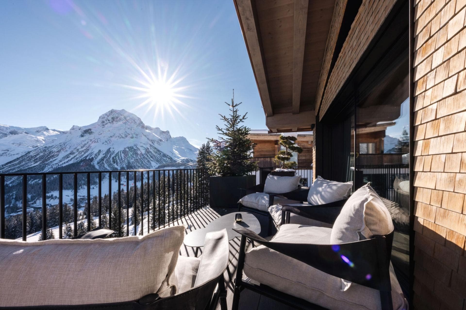 Private balcony with cushioned lounge seating and mountain views