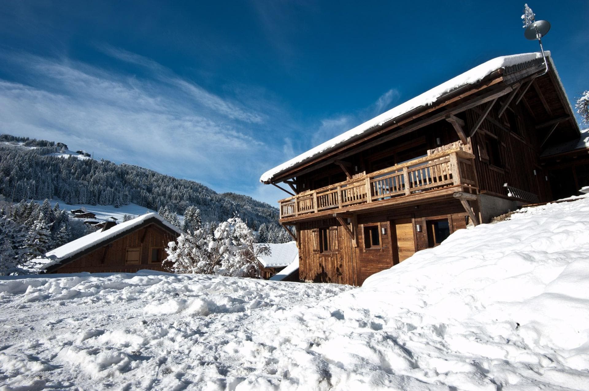 Ski-in chalet exterior with upper-level wrap-around balcony and mountain views