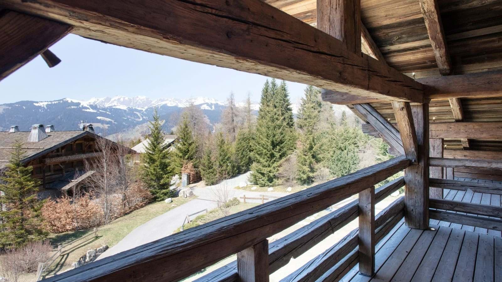 Covered balcony with timber beams and alpine mountain views