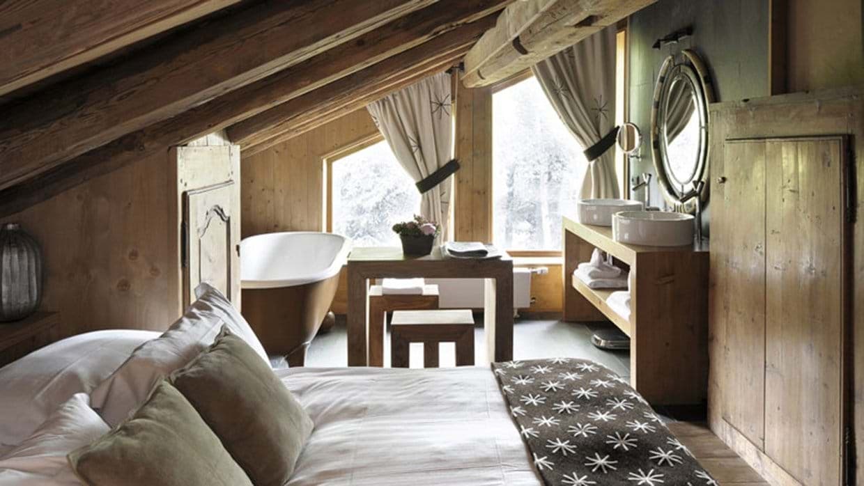 Loft bedroom suite featuring freestanding copper bathtub and dual vessel sinks