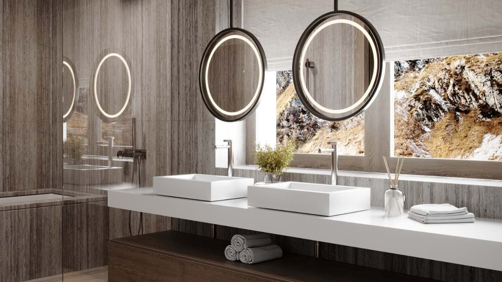 Bathroom with dual vessel sinks and backlit mirrors overlooking mountain views