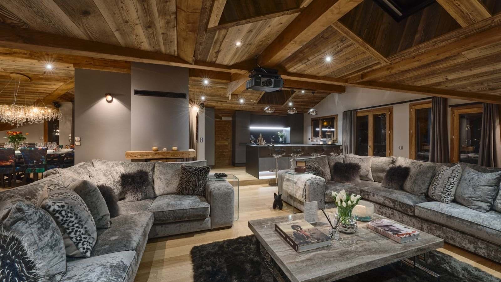 Open-plan living area with ceiling-mounted projector and sectional seating