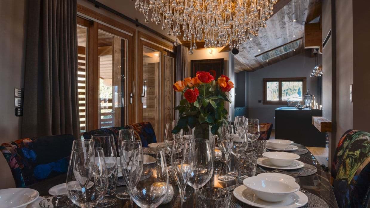 Dining area with crystal chandelier and mountain-view balcony access