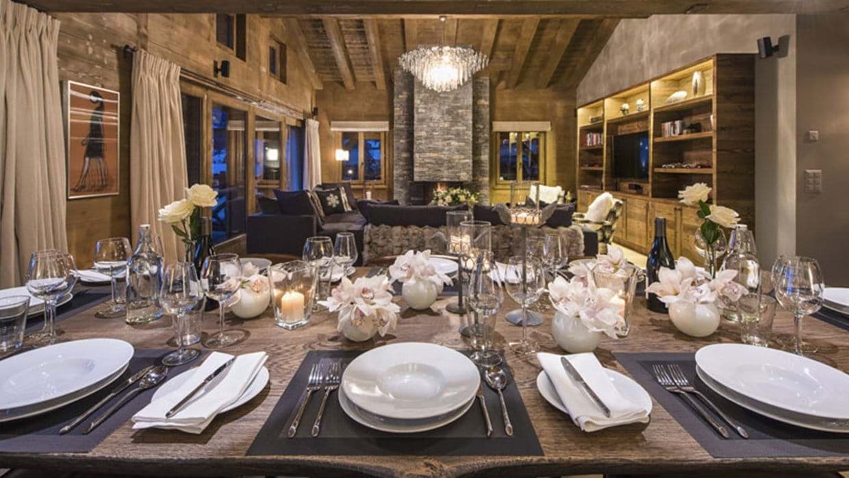 Open-plan dining and living area with floor-to-ceiling stone fireplace