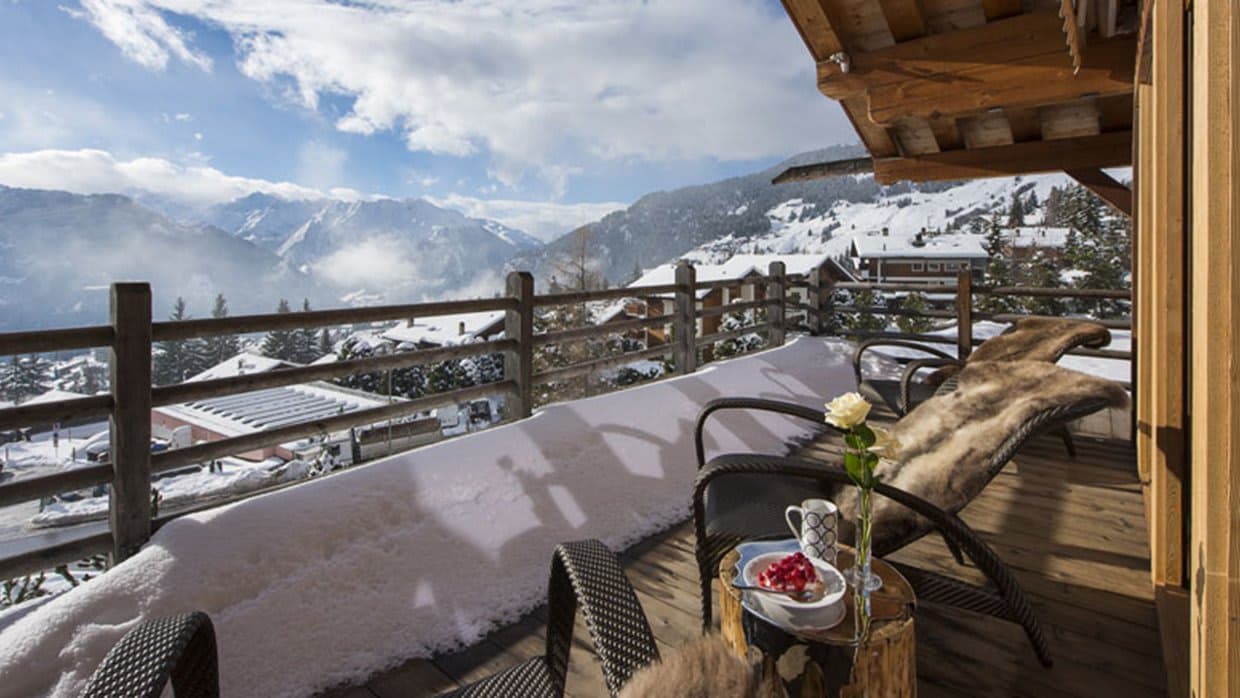 Private balcony with fur-lined lounge chairs and valley views