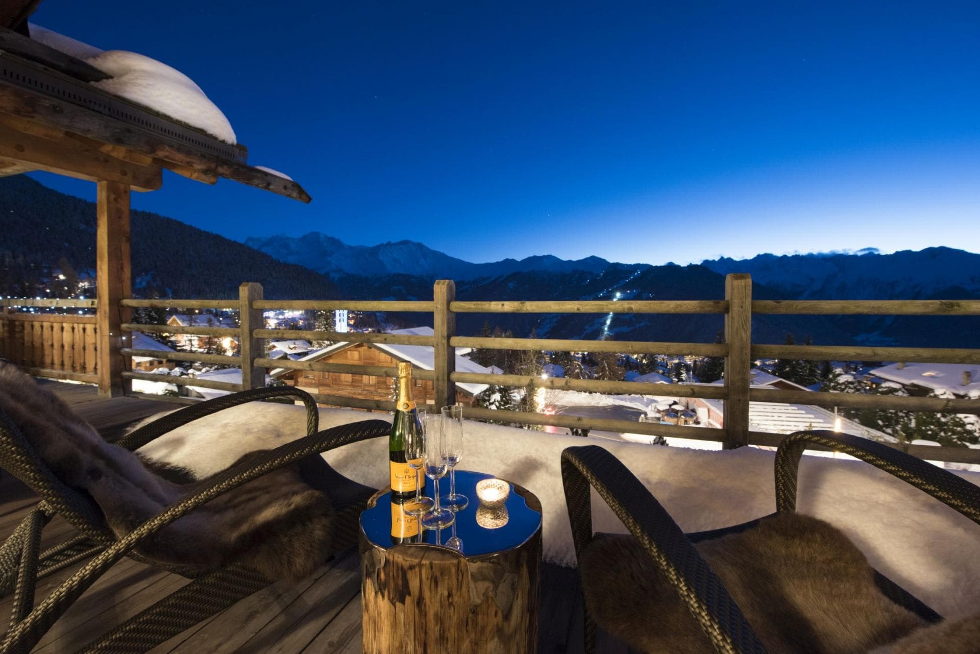 Private balcony with lounge seating and views of illuminated ski runs