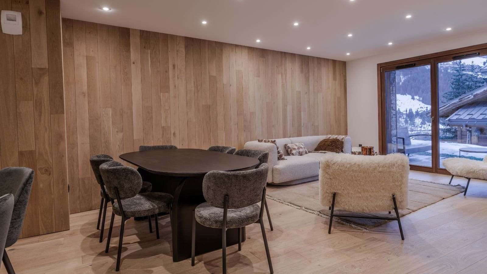 Open-plan living and dining area with sliding doors to snowy terrace