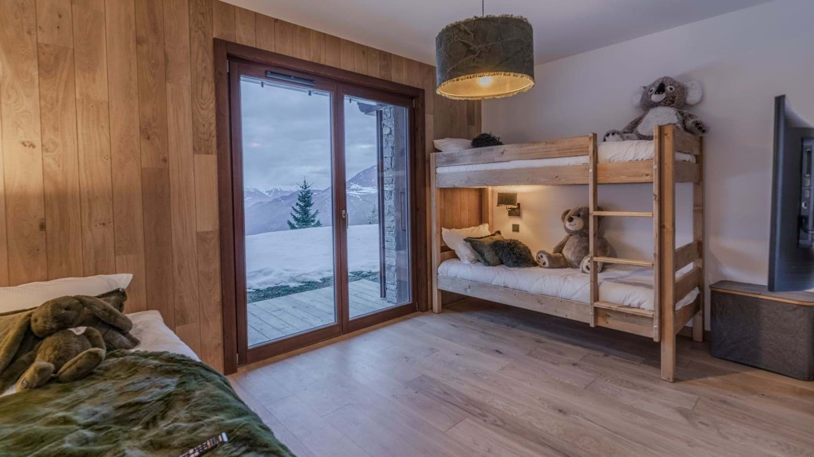 Bunk room with mountain-view patio access and wall-mounted TV