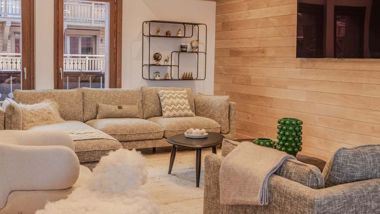 Living area with sectional seating and wood-paneled accent wall