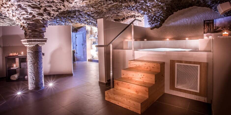 Indoor whirlpool spa set in a stone cellar with original rock ceiling
