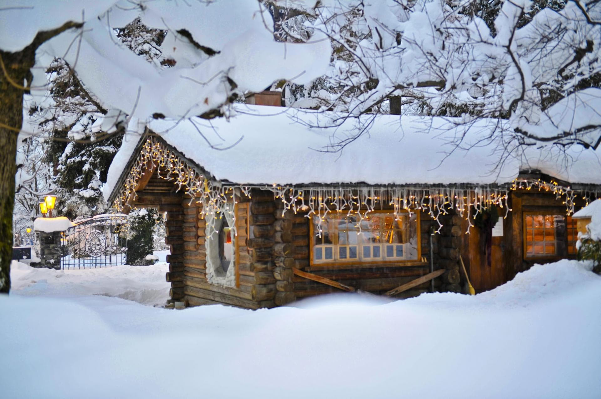 Log cabin exterior with decorative icicle lights and gated entry