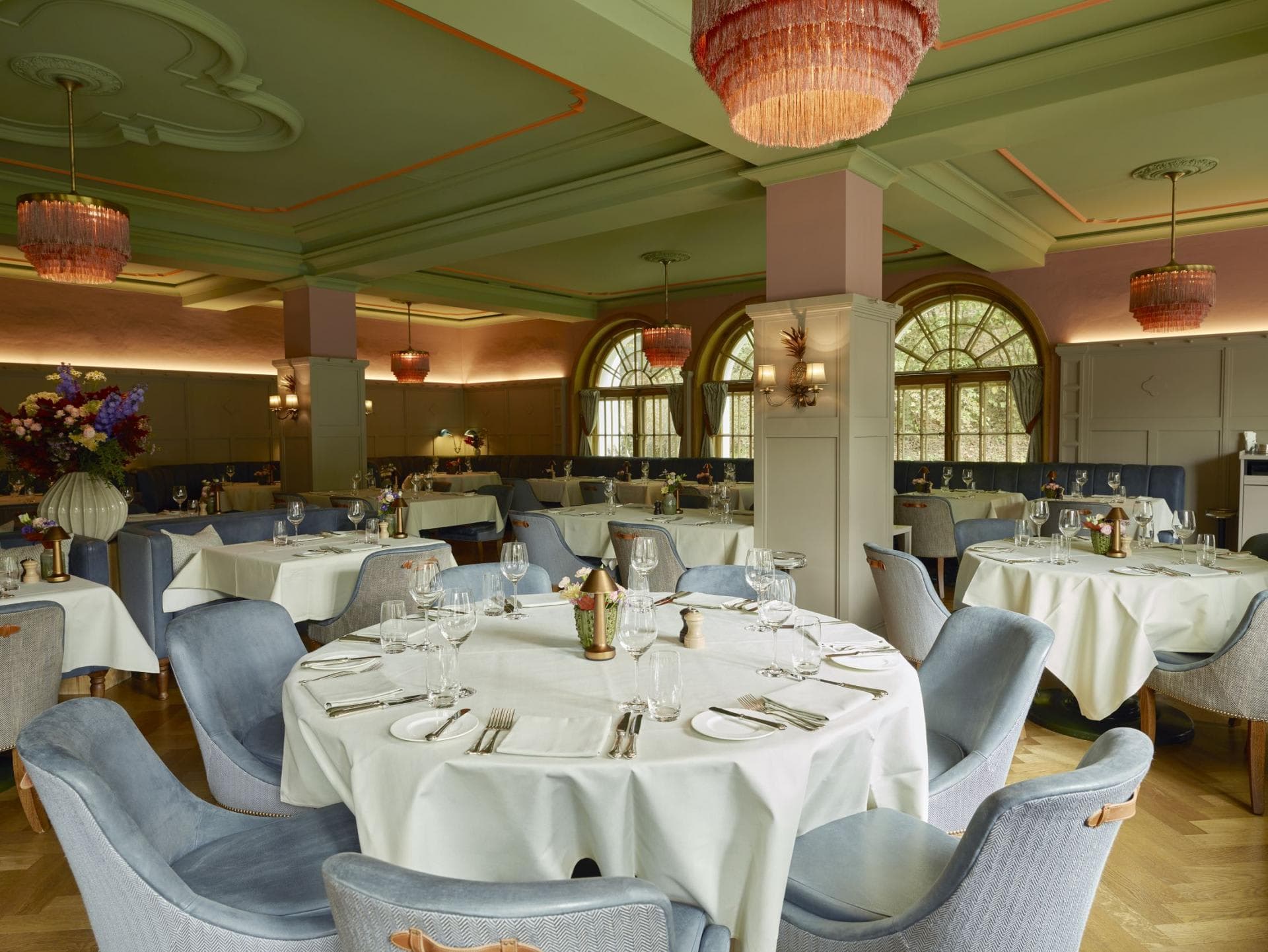 Dining room with parquet floors, banquette seating, and original arched windows
