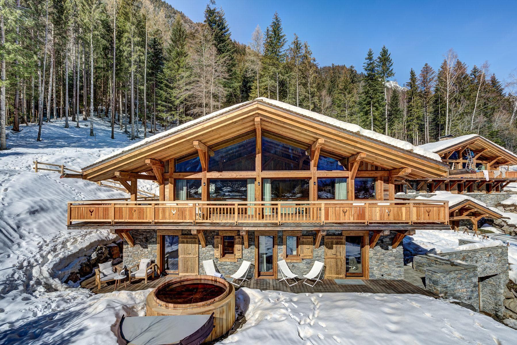 Ski-in chalet exterior with cedar hot tub and wrap-around sun deck