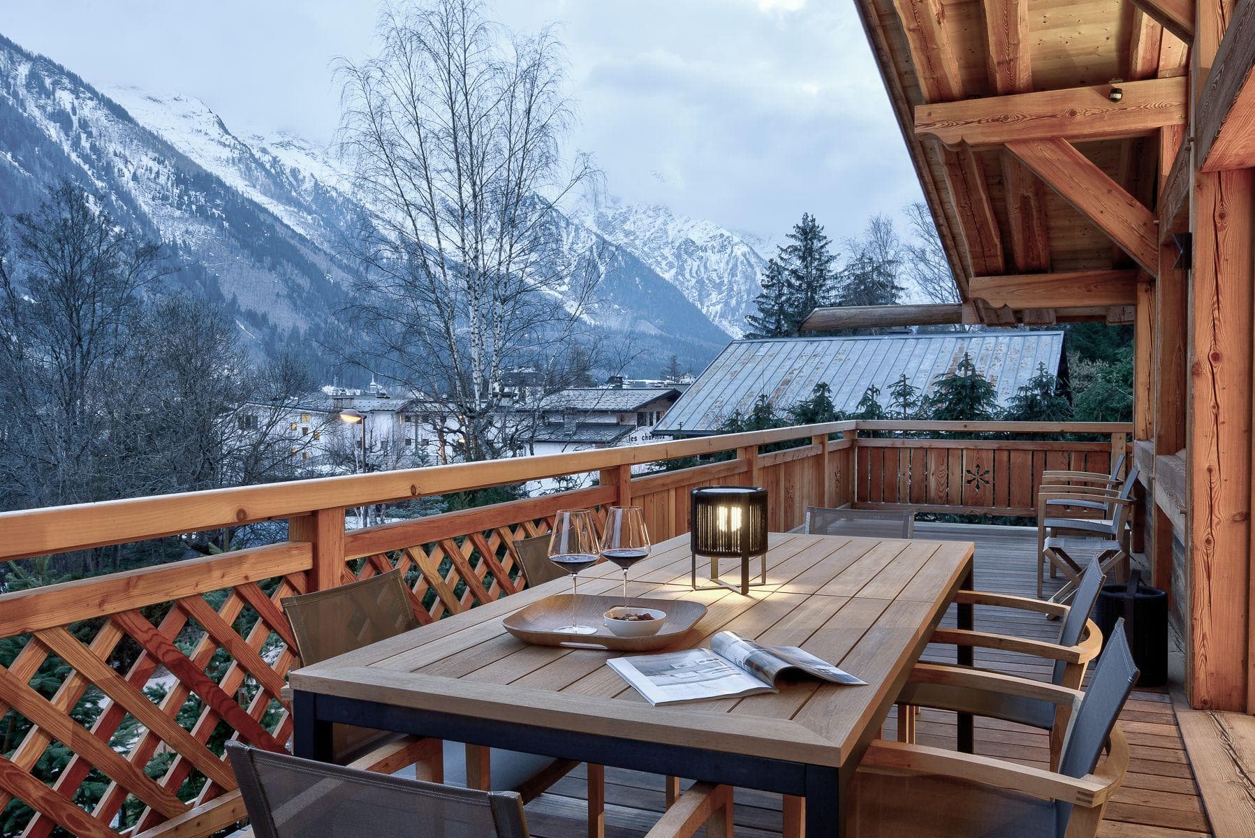 Covered wooden balcony with dining table for 6 and mountain views
