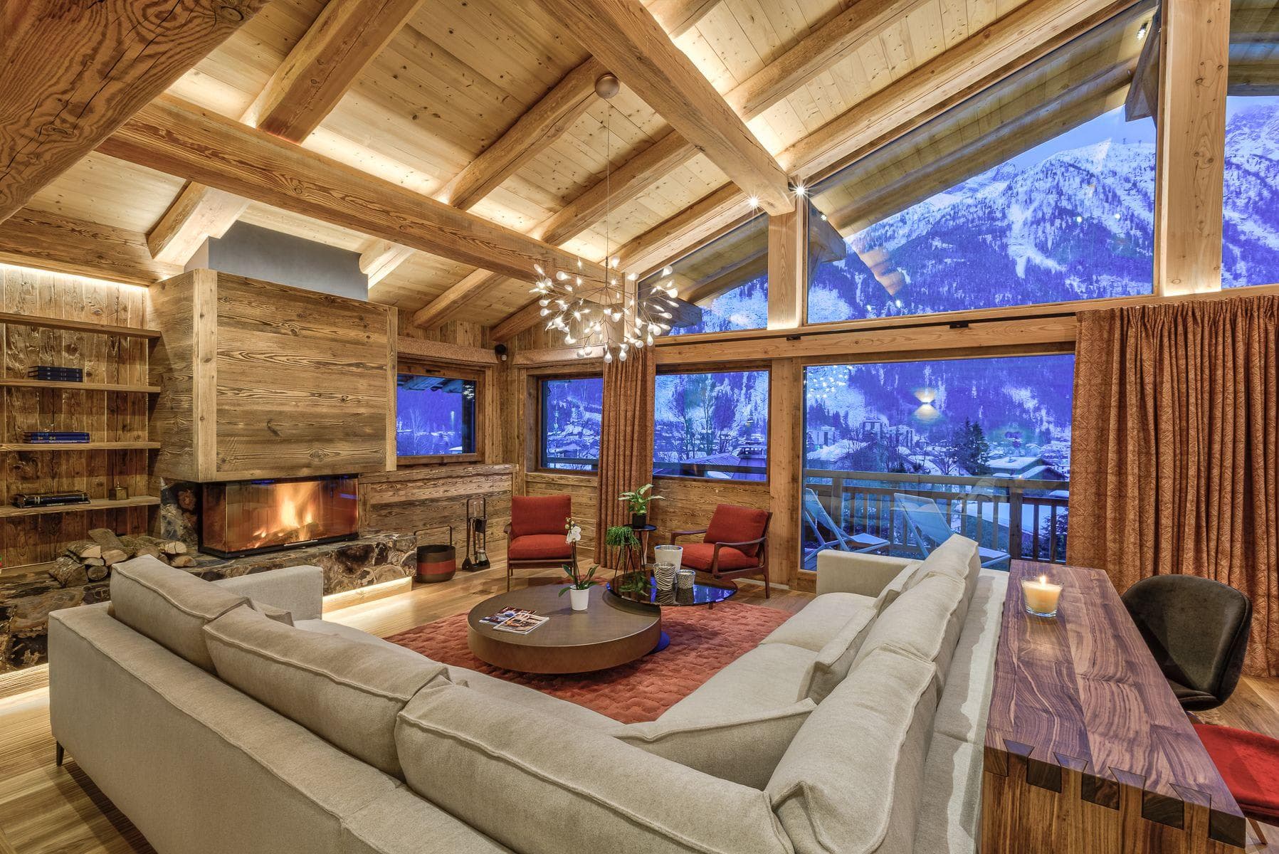 Living area with wood-burning fireplace and floor-to-ceiling mountain views