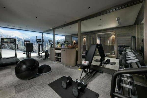 Fitness center with Technogym equipment and floor-to-ceiling mountain views