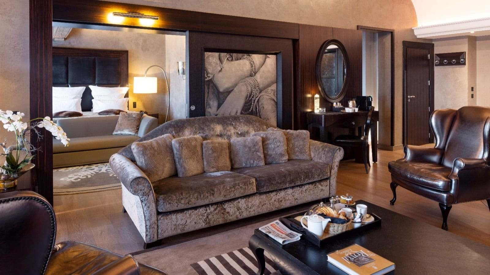 Suite living area with leather armchairs and desk; bedroom visible through sliding doors