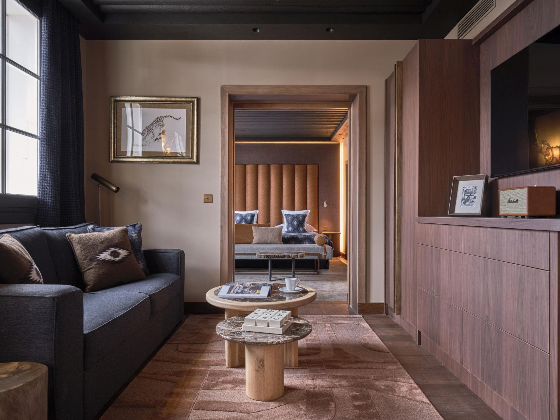 Sitting area with sleeper sofa and view into bedroom suite