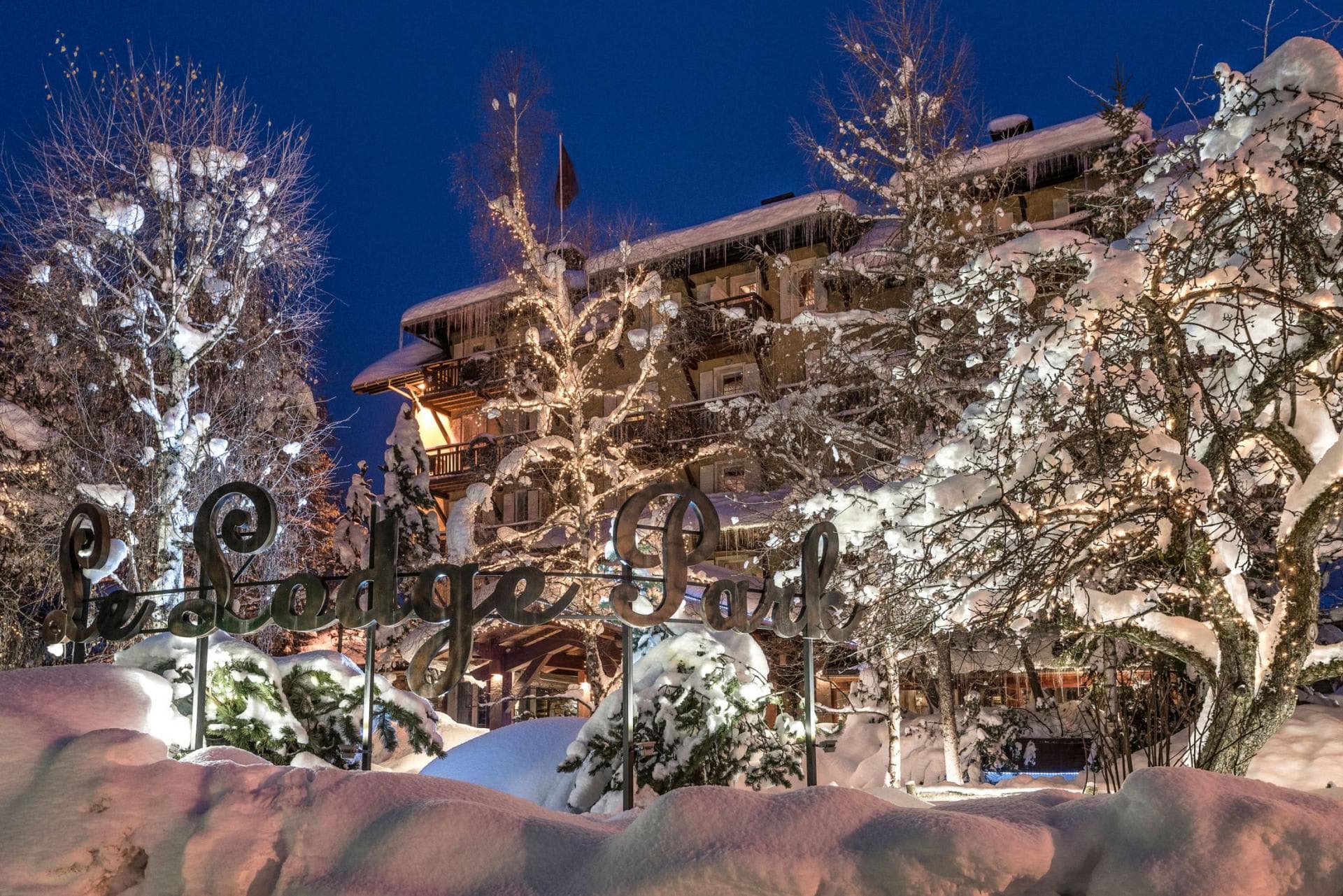 Chalet exterior at night with private balconies and snow-covered grounds