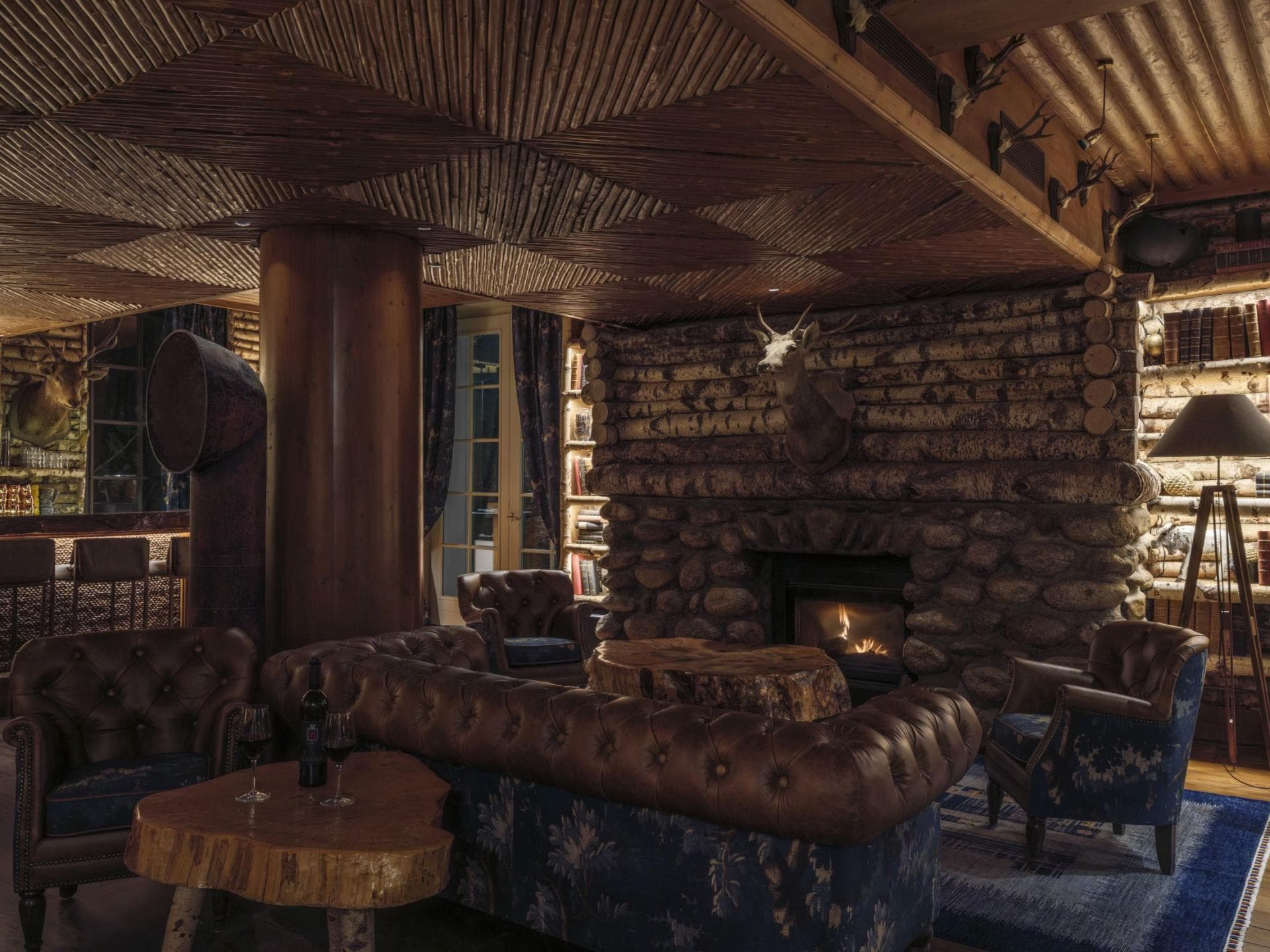 Lounge with wood-burning stone fireplace and tufted leather seating