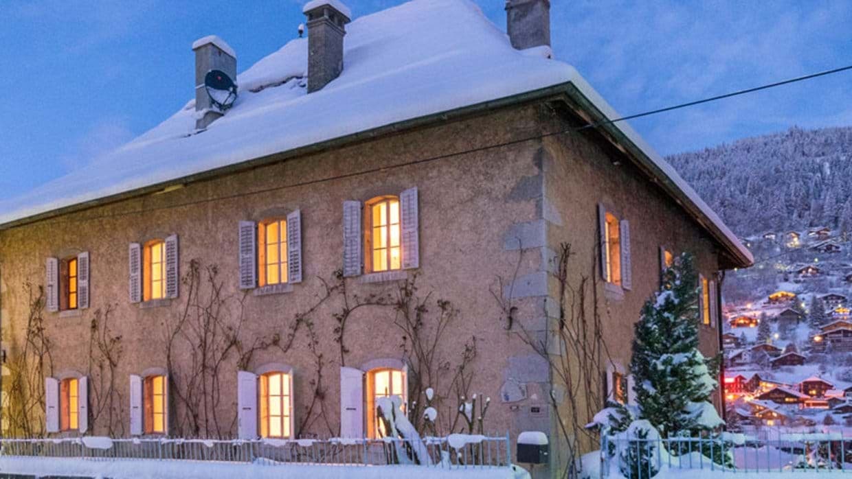 Stone chalet exterior featuring original shutters and valley village views