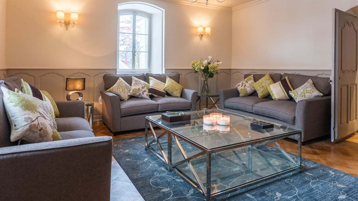 Living area with sofa seating for 6 and original wall paneling