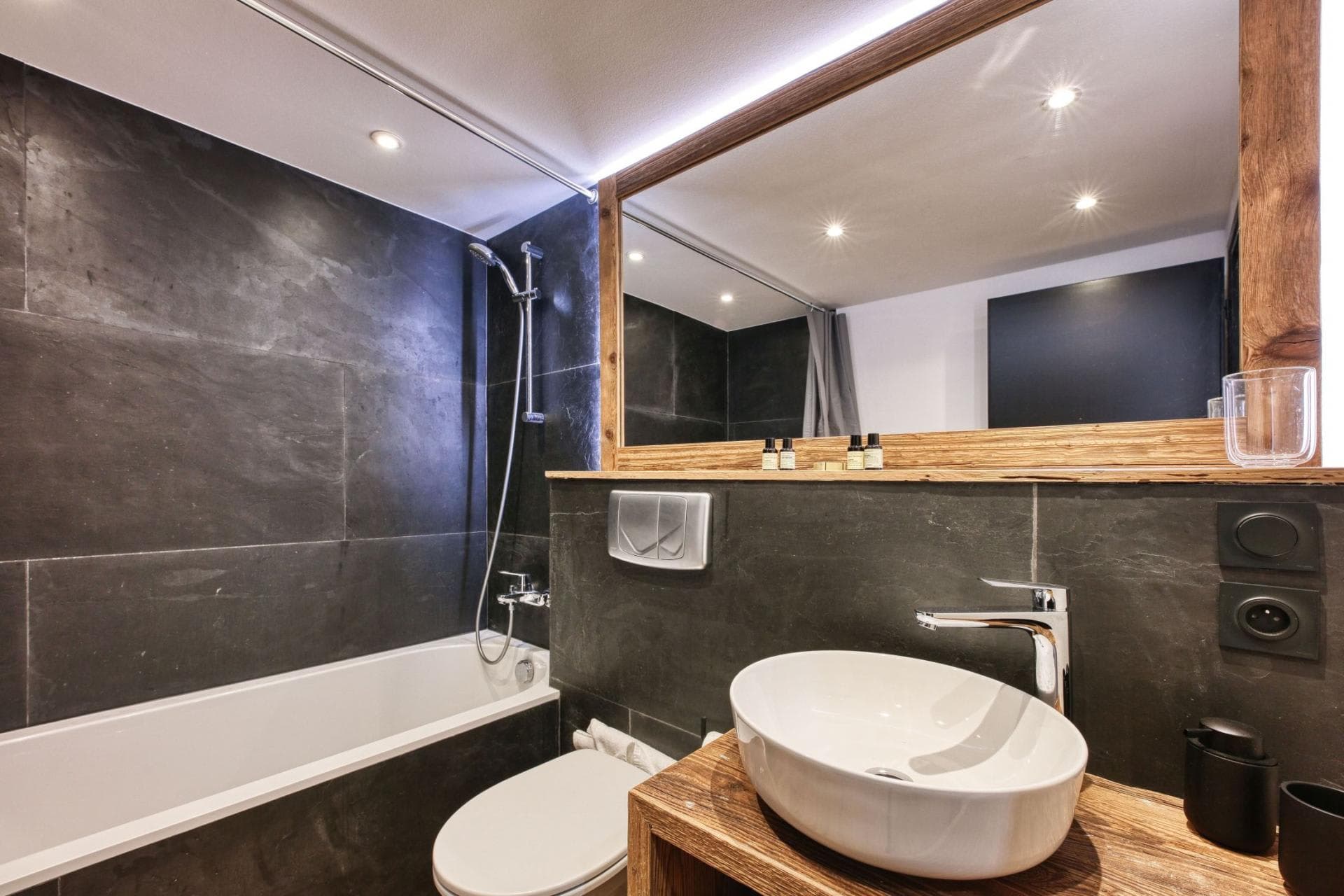 Bathroom with vessel sink and bathtub with handheld shower