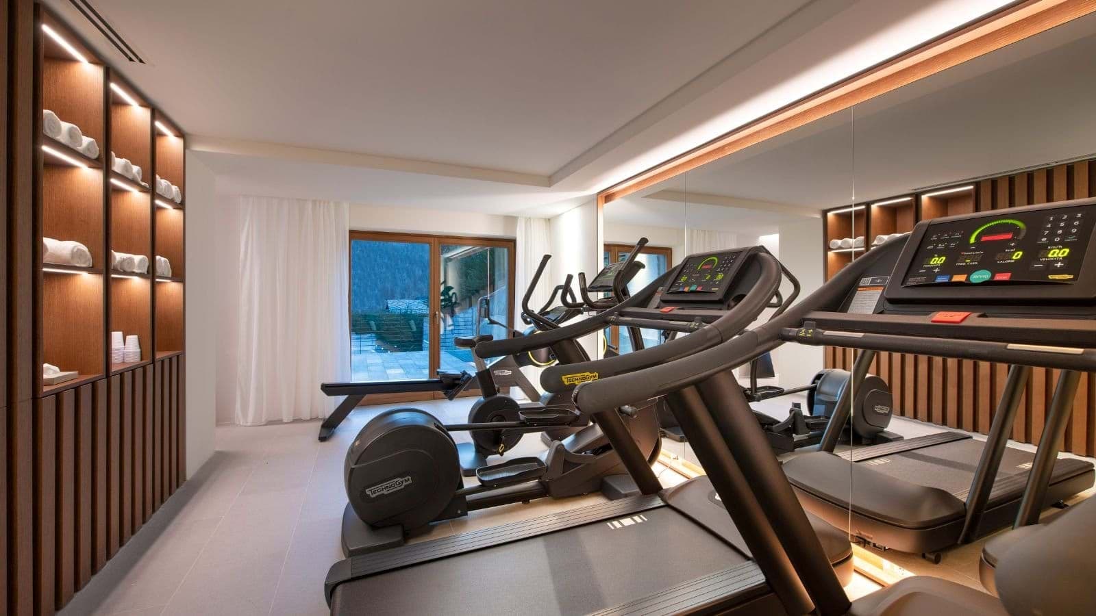 Fitness room with Technogym equipment, rowing machine, and provided towels