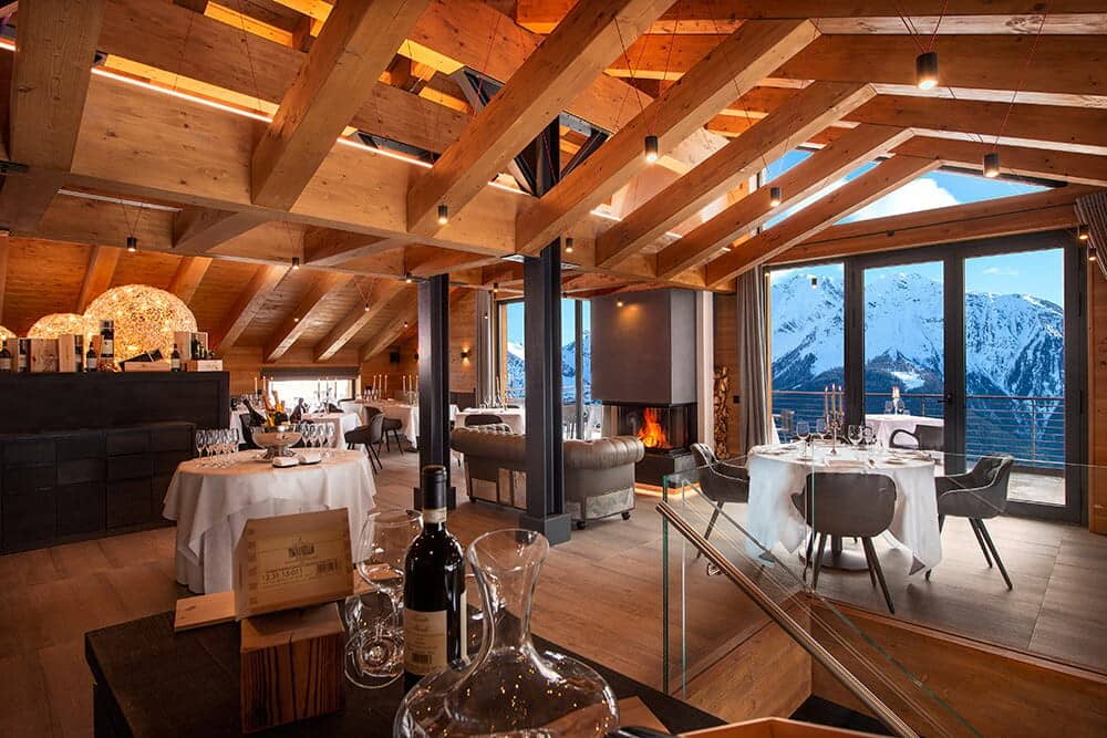 Dining room with wood-beam ceilings, fireplace, and mountain views