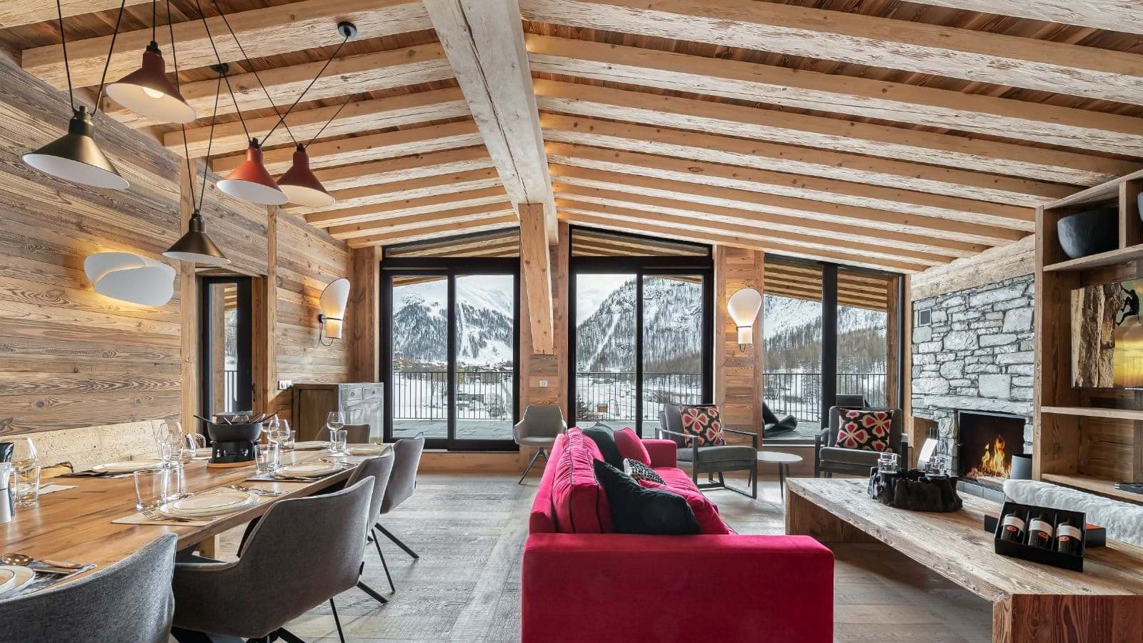 Open-plan living area with wood-burning fireplace and mountain-view balcony
