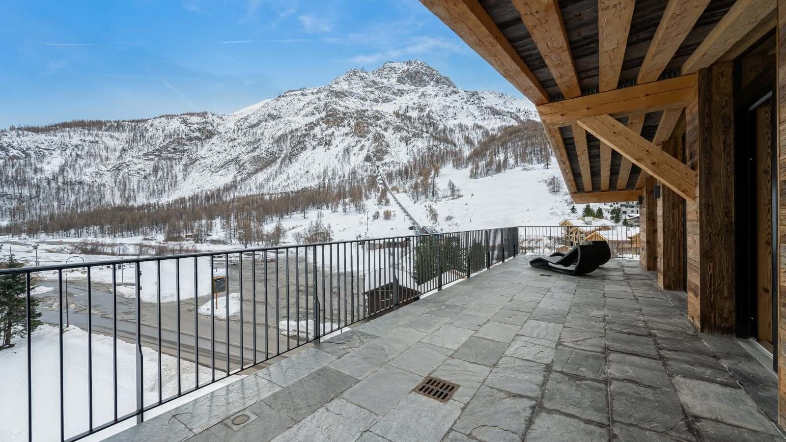 Stone-tiled balcony with mountain views and direct sun lounger access