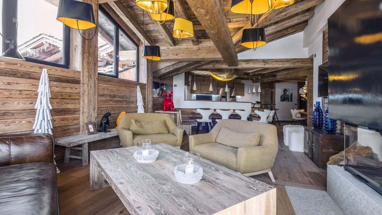 Open-plan living area with reclaimed wood beams and glass-enclosed fireplace