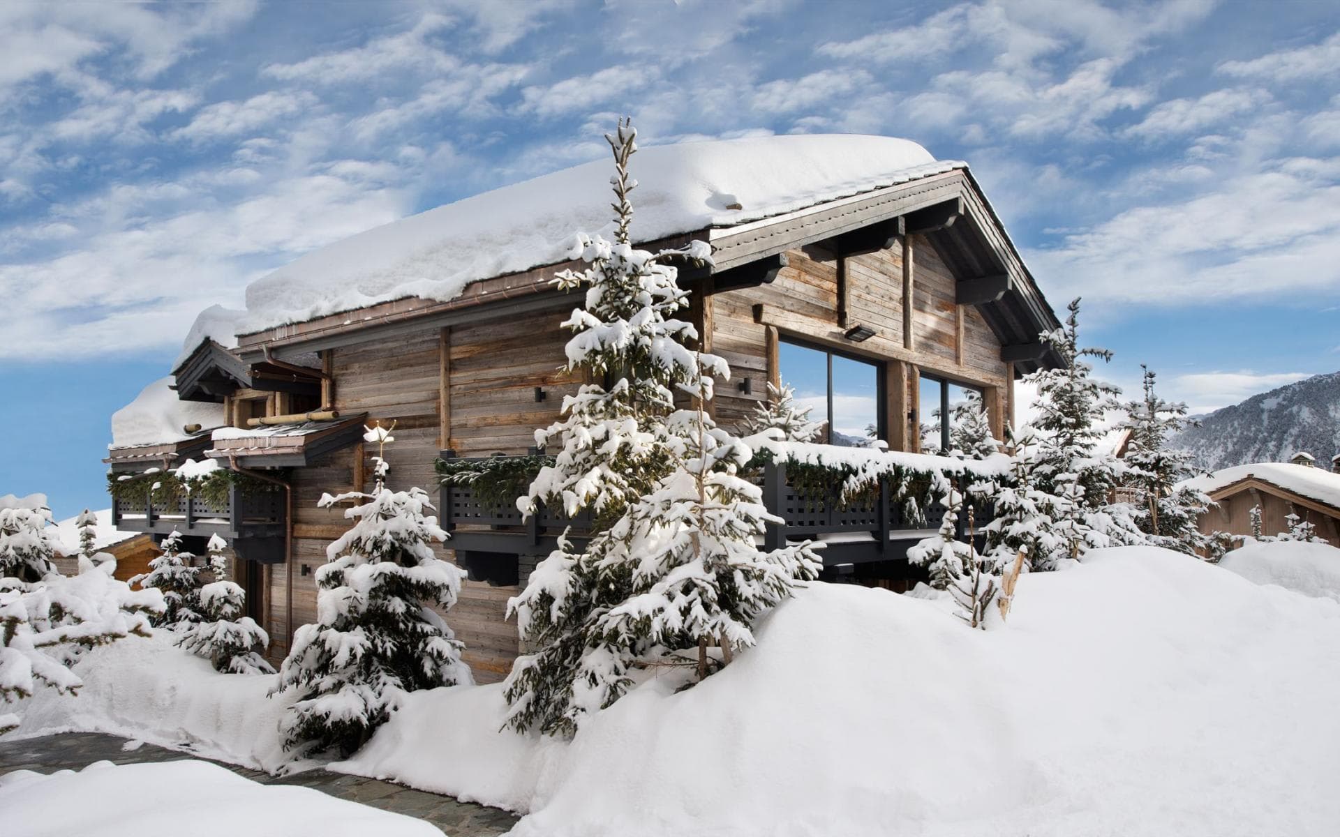 Timber chalet exterior with private balcony and panoramic mountain views
