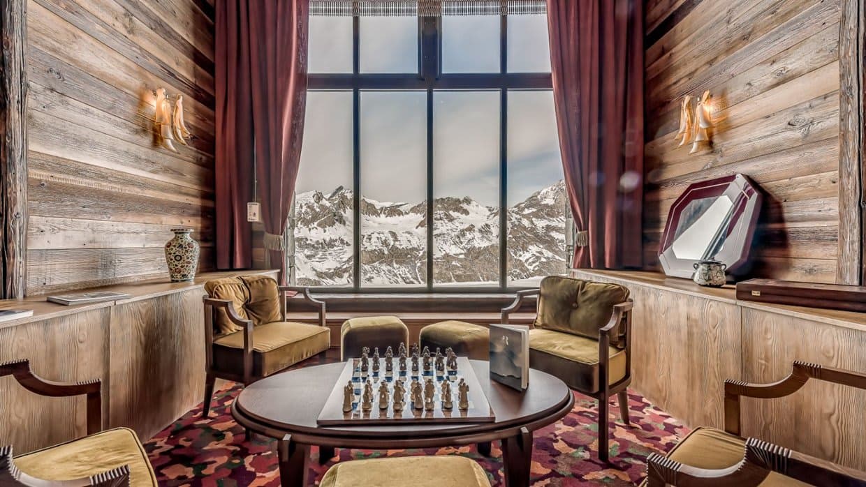Lounge area with chess table and floor-to-ceiling mountain views
