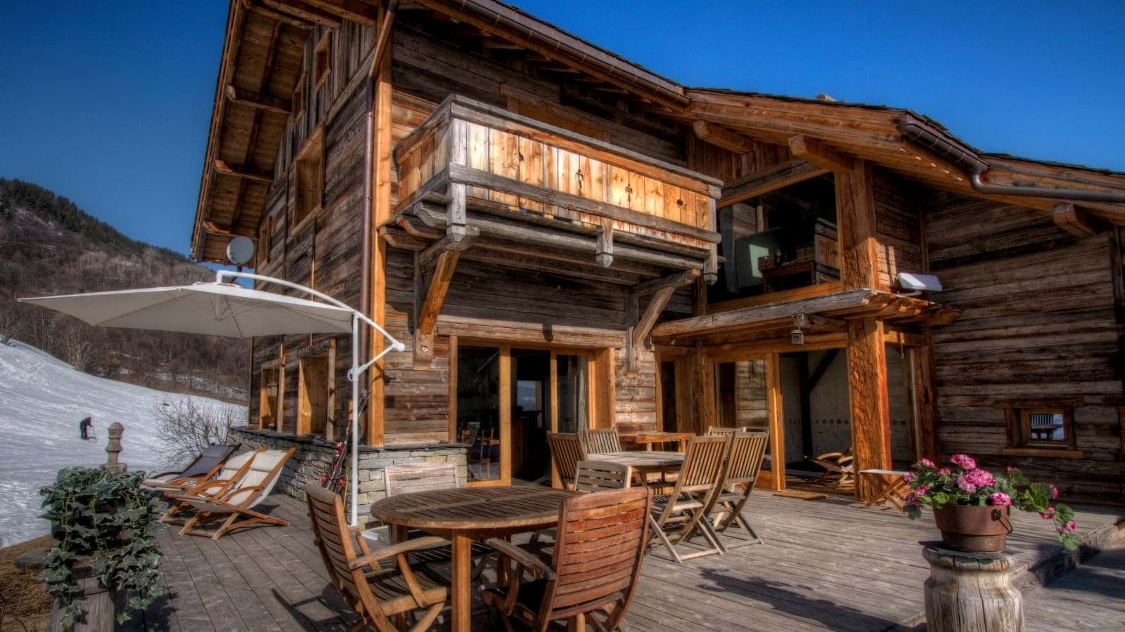 Timber deck with outdoor dining for 10 and loungers near ski run
