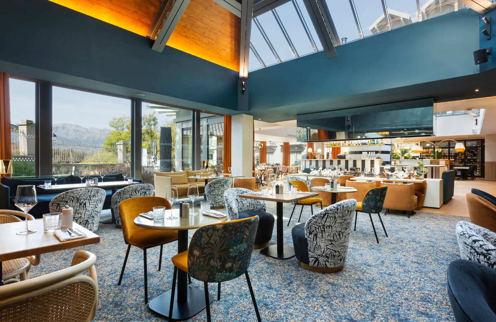 Atrium dining area with skylights and mountain views through floor-to-ceiling windows