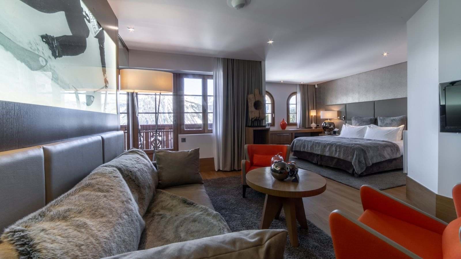 Open-plan suite with king bed, lounge area, and private balcony access