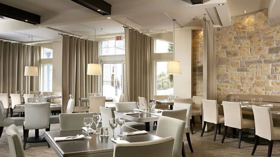 Dining area with privacy curtains and stone feature wall