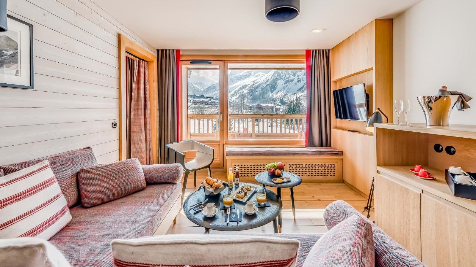 Living area with mountain-view balcony and window-side bench seating