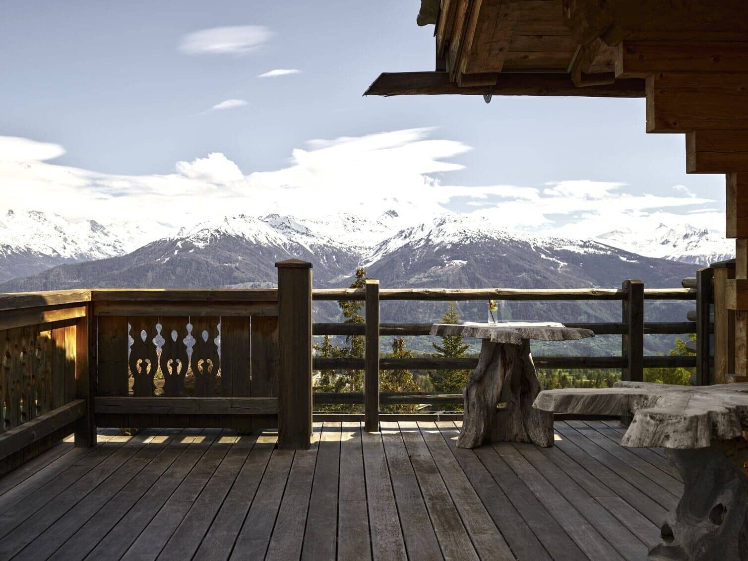 Private wooden deck with panoramic mountain views and carved timber seating
