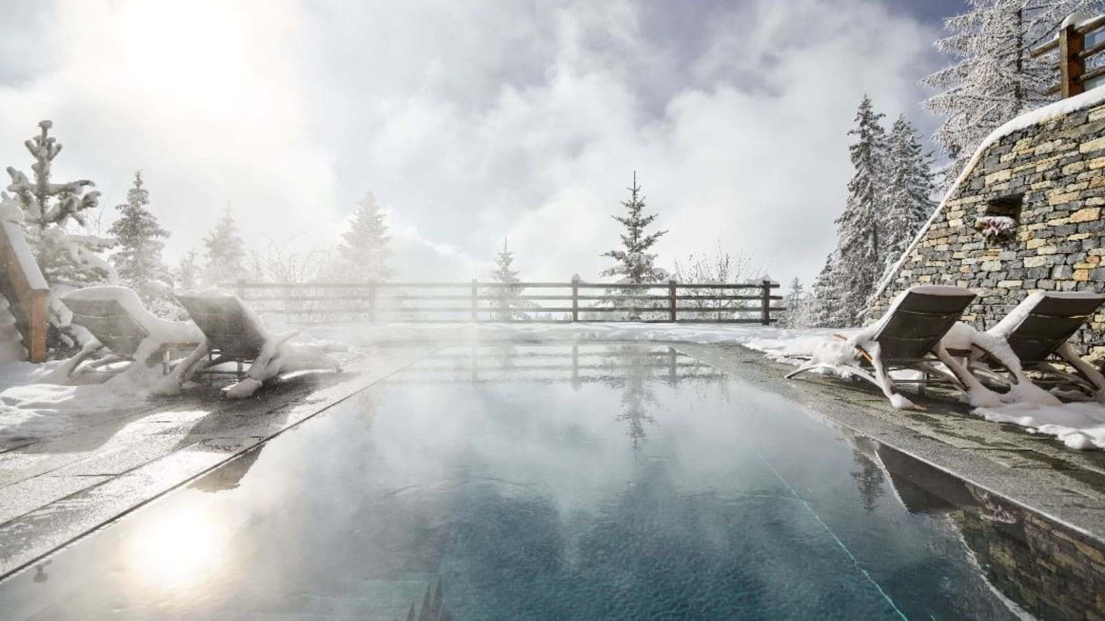 Heated infinity pool with mountain views and poolside loungers