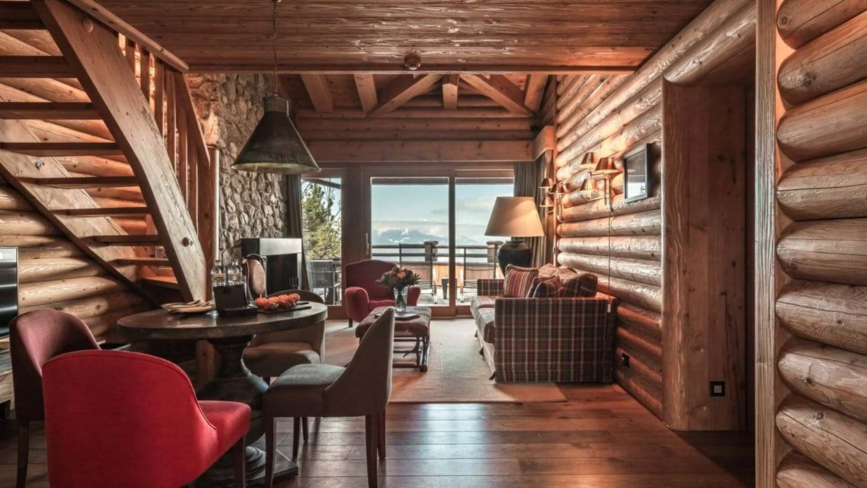 Open-plan living area with log walls and private balcony access