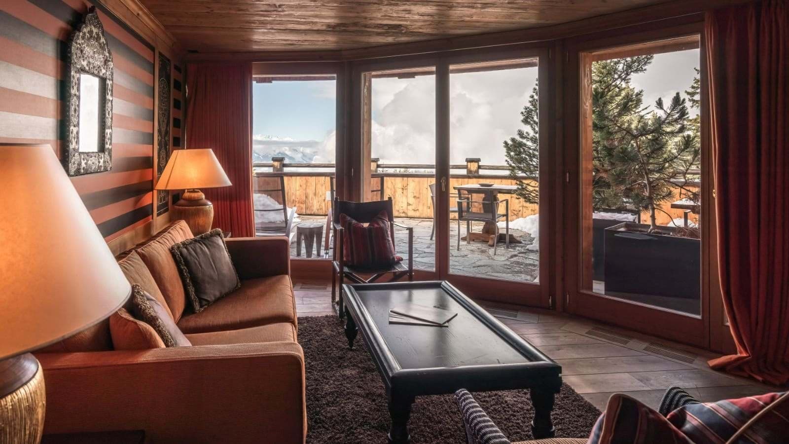 Living area with floor-to-ceiling windows and private snowy terrace access