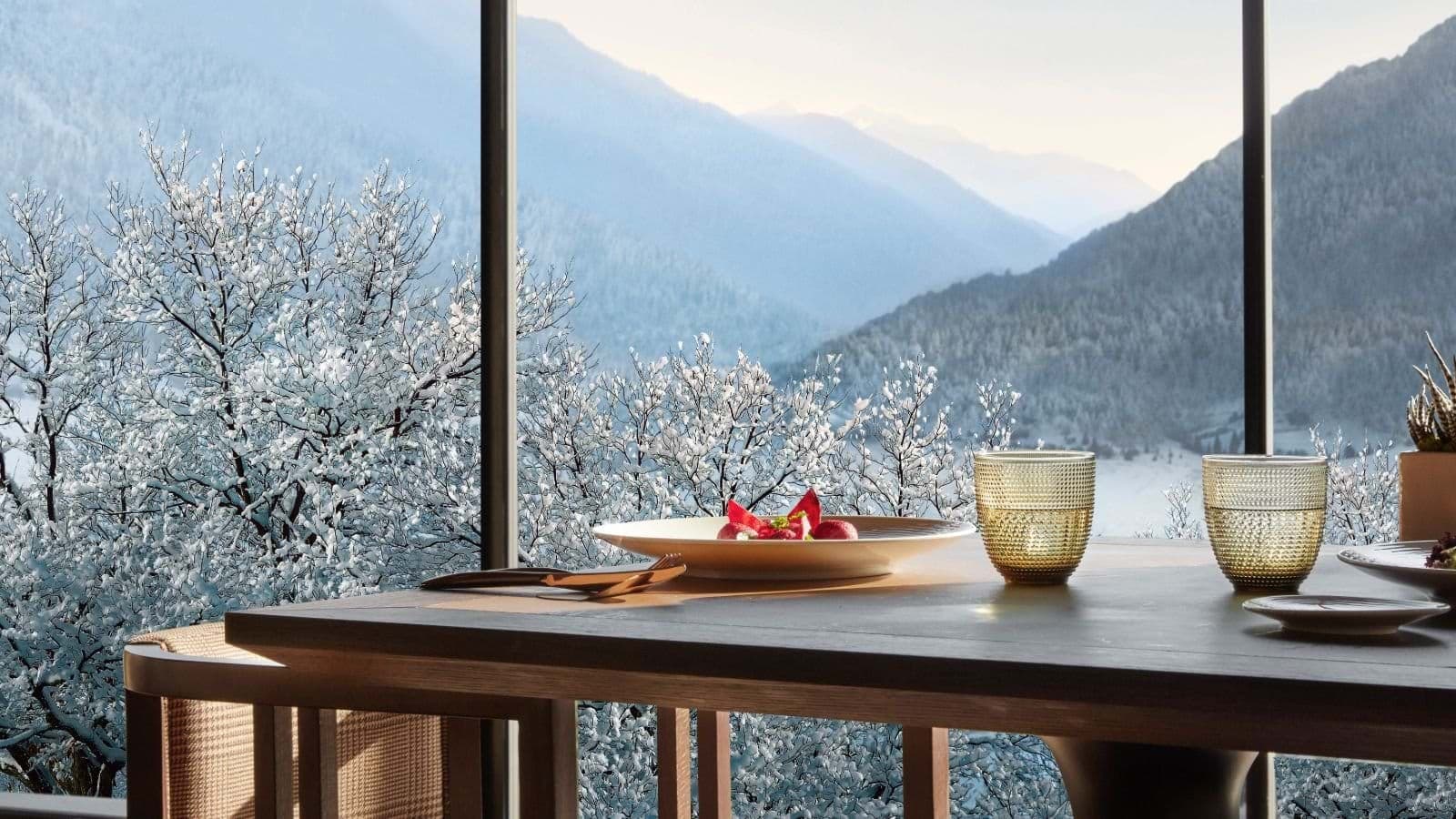 Dining area with floor-to-ceiling windows and panoramic alpine valley views