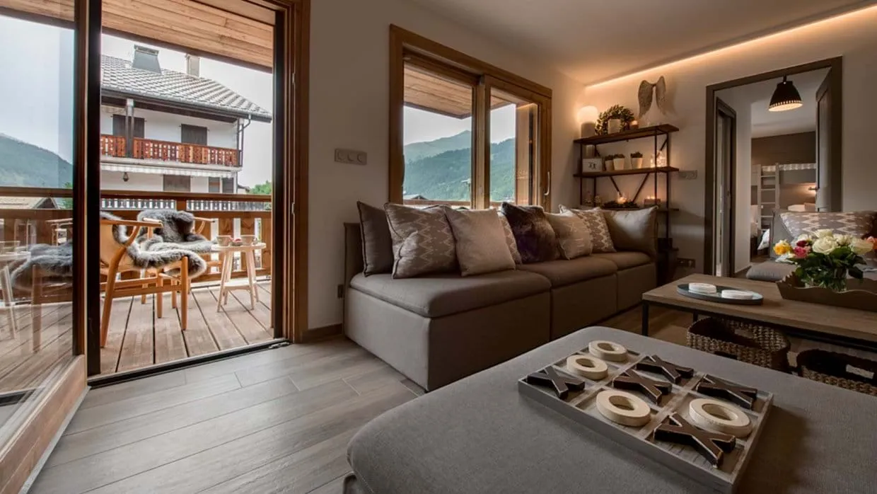 Open-plan living area with doors to a mountain-view balcony