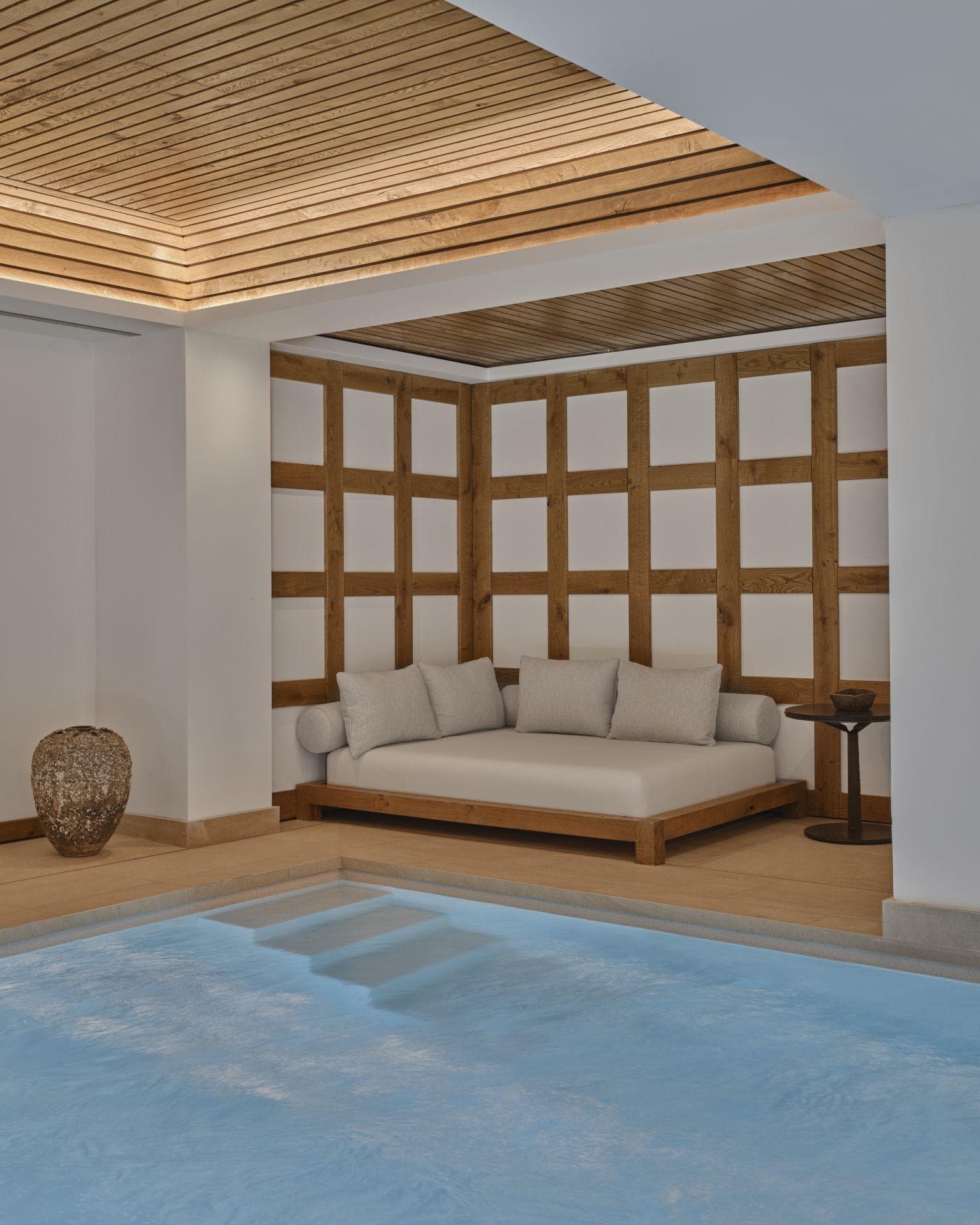 Indoor pool area with daybed seating and recessed cove lighting